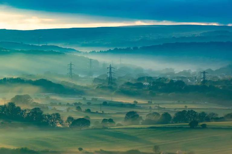 A scenic view of a valley filled with trees and rolling hills, showcasing the beauty of nature and energy efficiency