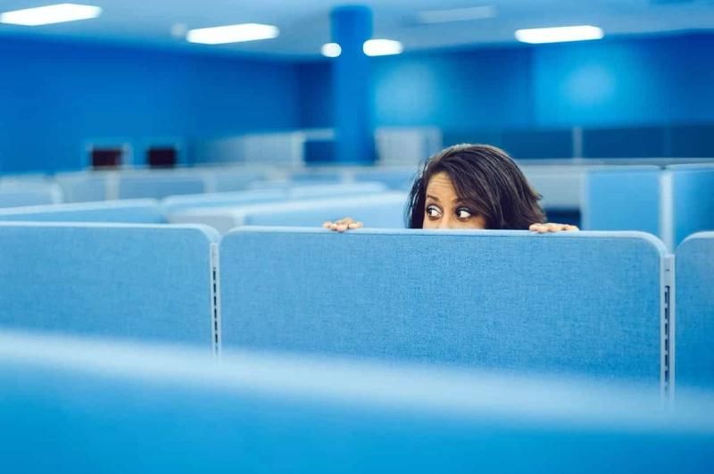 Person looking over an office cubicle