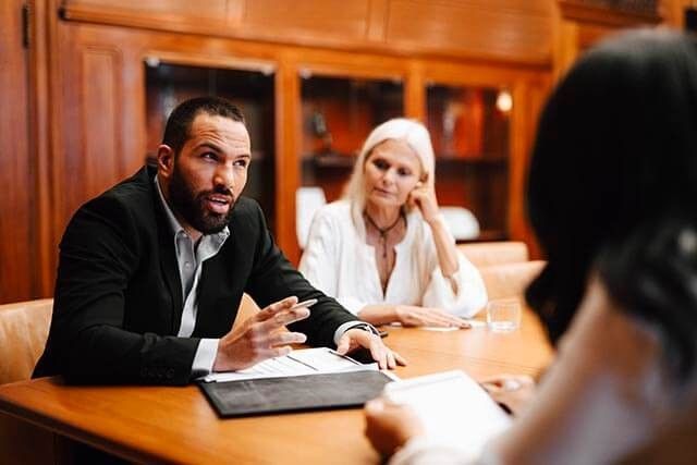 Two women and a man are engaged in a discussion or a business meeting.
