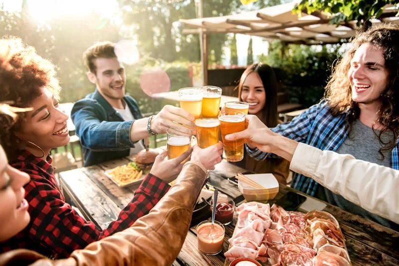 Young people drinking beer at pub outdoors
