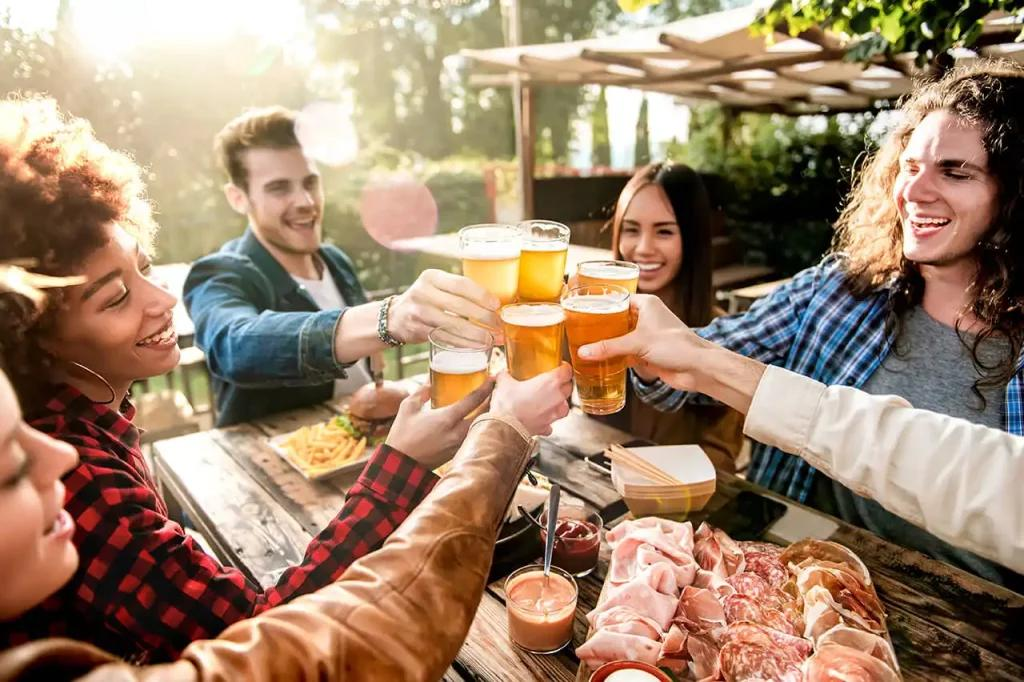 Young people drinking beer at pub outdoors