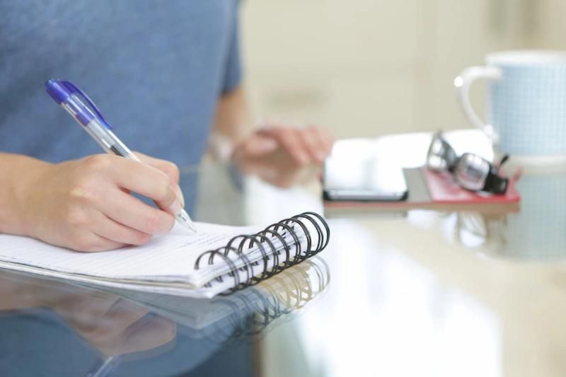 Person writing notes on a notepad
