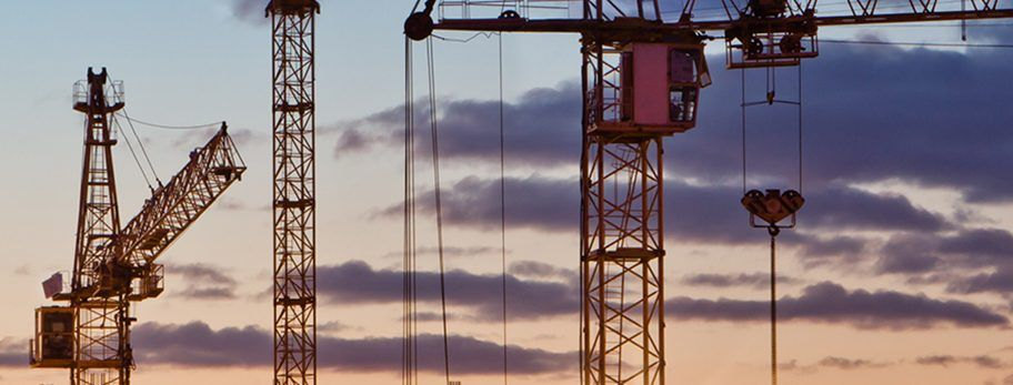Construction cranes skyline at sunset