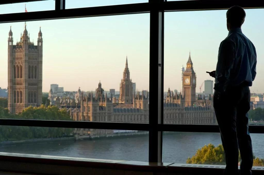 Person looking out of a window at Westminster and the London skyline