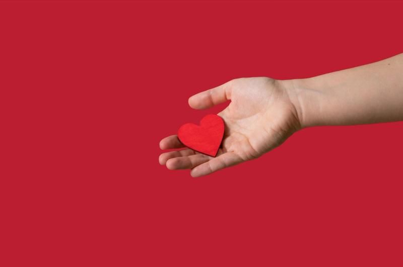 Open hand holding a paper love heart