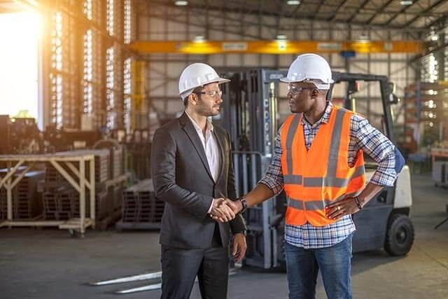 men in warehouse shaking hands