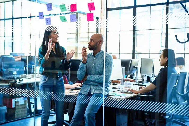Two professionals meeting in an open plan office
