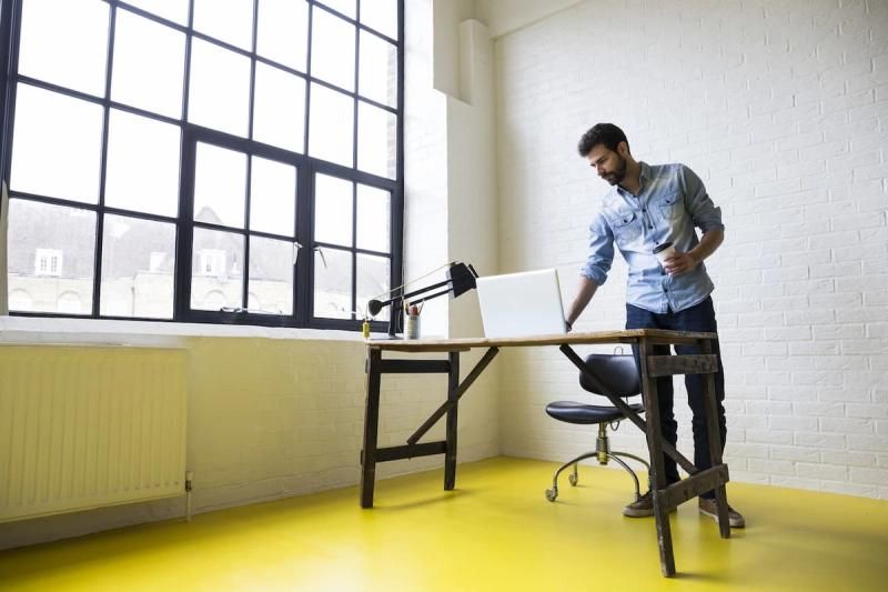 Person setting up a new desk next to a large window